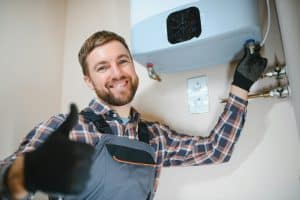 Professional plumber checking a boiler and pipes, boiler service concept